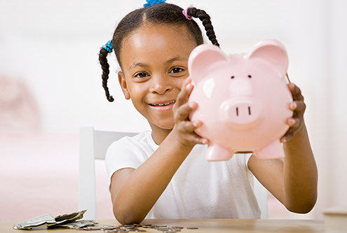 little girl holding a piggy bank